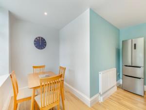 a kitchen with a table and chairs and a refrigerator at Arnside Apartment in Lindale