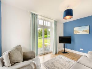 a living room with a couch and a tv and a window at Arnside Apartment in Lindale