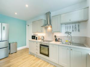 a kitchen with white cabinets and stainless steel appliances at Arnside Apartment in Lindale