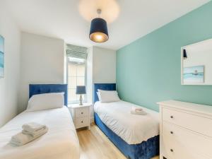 two beds in a bedroom with blue and white at Arnside Apartment in Lindale +9 photos