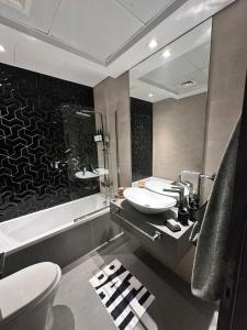 Un baño con dos lavabos, un inodoro y un espejo. en 5-Star Vibes Modern Studio Business Bay, en Dubái