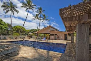 a swimming pool with palm trees in the background at Kihei Akahi C302 · AKH C302 Spacious 2BD Condo w Ocean Breeze AC in Wailea