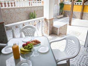 a white table with a plate of fruit and juice at Bungalow in Parque Las Naciones with Communal Pool in Torrevieja