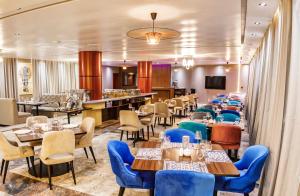 un restaurant avec des tables et des chaises et un bar dans l'établissement Swiss International Rancho Valeria, Warri, à Warri