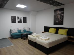 a hotel room with a bed and a couch at Hostel Tsanovi in Pleven