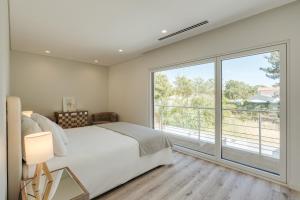 ein Schlafzimmer mit einem Bett und einem großen Fenster in der Unterkunft Paraty Villa in Aroeira + 45 Fotos