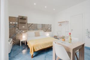 a bedroom with a bed and a dining table at Oikos Design in Castellammare del Golfo