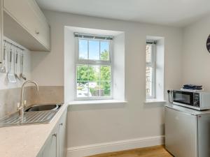 een witte keuken met een spoelbak en een magnetron bij Baycliff Apartment in Lindale