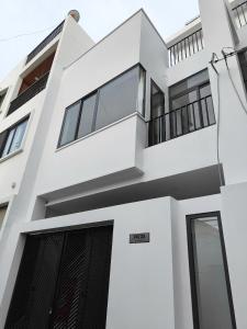 a white house with a black door at Town House for rent in Thủ Đức in Ho Chi Minh City