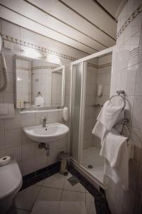 a bathroom with a sink and a shower with towels at MC Hotel in Žalec