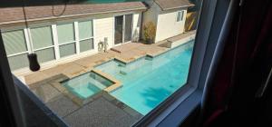 uma vista de uma piscina de uma janela em Modern Condo, Private, Home Feel, No Shared Walls em Katy
