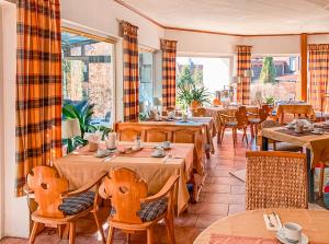 a restaurant with tables and chairs in a room at Hotel Carlsruh in Braunlage