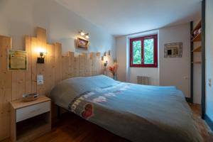 ein Schlafzimmer mit einem großen Bett mit Holzwänden in der Unterkunft Gites D'étape Les Carlines in Vassieux-en-Vercors