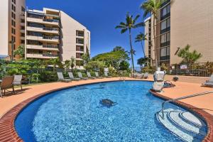 a large swimming pool with chairs and a building at Valley Isle 206 · VI 206 OceanFront Studio w Pool in Kahana