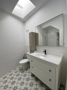a bathroom with a sink and a toilet and a mirror at Casa Típica con Terraza in Ayamonte