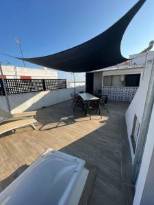 a patio with a table and chairs on a roof at Casa Típica con Terraza in Ayamonte