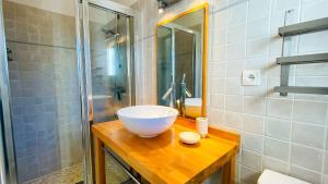 ein Badezimmer mit einem Spülbecken auf einer Holztheke in der Unterkunft Villa récente de style réthais avec piscine chauffée et jardin paysager in Le Bois-Plage-en-Ré + 8 Fotos