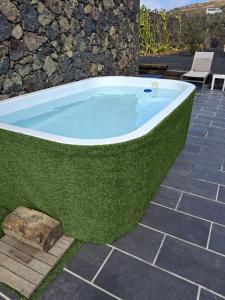 a jacuzzi tub with green grass on a patio at Finca la Molina Lanzarote in Haría