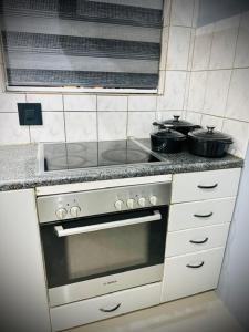 a kitchen with a stove with two pots on it at Y & N BnB in Alberton
