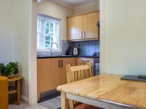 une cuisine avec des armoires en bois et une table en bois dans l'établissement Flat 1 - Uk50224, à Tetsworth