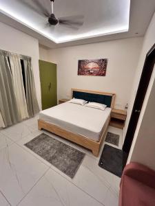 a bedroom with a bed and a ceiling at Joshi Homestay in Dehradun +9 photos