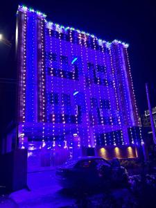 a building is lit up with blue and purple lights at Joshi Homestay in Dehradun