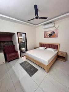 a bedroom with a bed and a red chair at Joshi Homestay in Dehradun