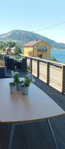 a wooden table with two potted plants on a deck at Renovated Chapel With Fjord Views In Vågstranda in Reistad +13 photos