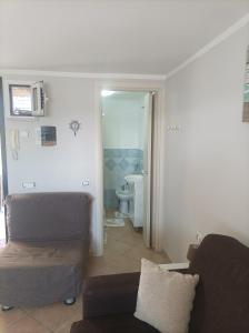 a living room with a couch and a bathroom at Casina sulla Sabbia in Torvaianica