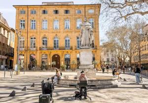 a statue of a woman sitting on a bench in front of a building at Le Richelme by Rentalaix in Aix-en-Provence