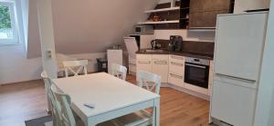 a kitchen with a white table and a white refrigerator at Wohnung für Monteure und beruflich Reisende in Petershagen