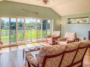 a living room with a couch and chairs at Cedar Lodge in Old Buckenham