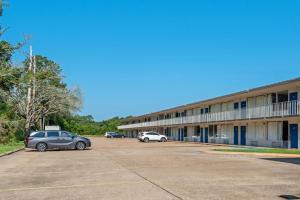 a building with two cars parked in a parking lot at Studio 6 Hammond, LA I12 I55 in Hammond