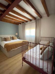 a bedroom with two beds in a room with wooden ceilings at Villa Dorotea - Casa Rural Vallines in Vallines