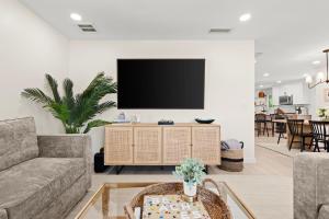 a living room with a flat screen tv on a wall at Luxury Home 6 Blocks From Flagler Ave & Beach Access Across the Street in New Smyrna Beach