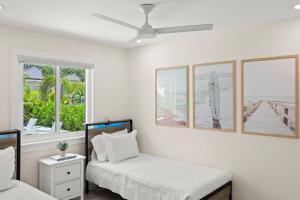 a bedroom with two beds and two windows at Luxury Home 6 Blocks From Flagler Ave & Beach Access Across the Street in New Smyrna Beach +23 photos