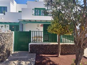 a house with a green gate and a tree at Casa Real in Playa Blanca