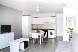 a white kitchen with a table and chairs at Casa Real in Playa Blanca