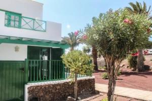 a green and white house with trees in front of it at Casa Real in Playa Blanca +2 photos
