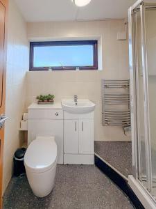 a bathroom with a toilet and a sink at Russet Grove in Earlham +12 photos