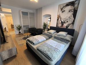 レオーベンにあるWohnung in Leoben Zentrum Zwischen Hauptplatz und Stadtparkの壁に大きな絵が飾られたベッドのある寝室 +9枚の写真