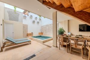 uma sala de estar em plano aberto com uma piscina, uma mesa e cadeiras em Casa Encanto - Corazón de Getsemaní em Cartagena de Indias