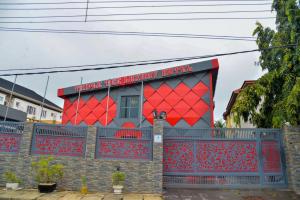 a building with a red roof on top of a fence at Triple Tee Luxury Hotel & Service Apartments Surulere in Lagos