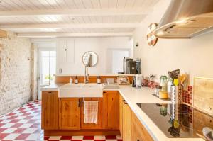 a kitchen with a sink and a counter top at Longère de charme avec piscine, proche océan in Lairoux