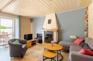 a living room with a couch and a fireplace at Longère de charme avec piscine, proche océan in Lairoux