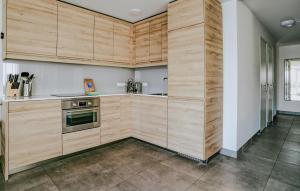 a kitchen with wooden cabinets and a stove at Westergeest Luxe in Uitgeest