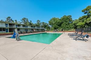 a swimming pool with two chairs and a slide at Studio 6 Hammond, LA I12 I55 in Hammond