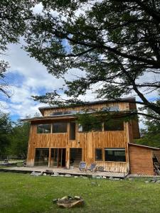 a house with two chairs in front of it at Preciosa casa V. Cerro Castillo cercana Parque in Villa Cerro Castillo