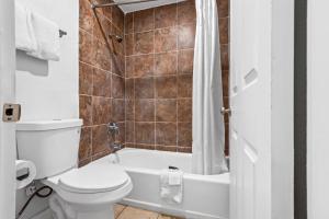 a bathroom with a toilet and a tub and a sink at Studio 6 Hammond, LA I12 I55 in Hammond