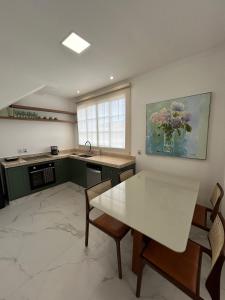a kitchen with a white table and chairs and a window at Sobrado da Matriz in São Lourenço +11 photos